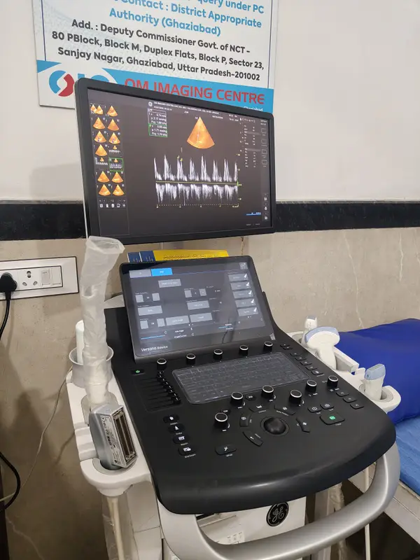 Ultrasound machine with a monitor and control panel in a scanning room at Om Imaging Centre